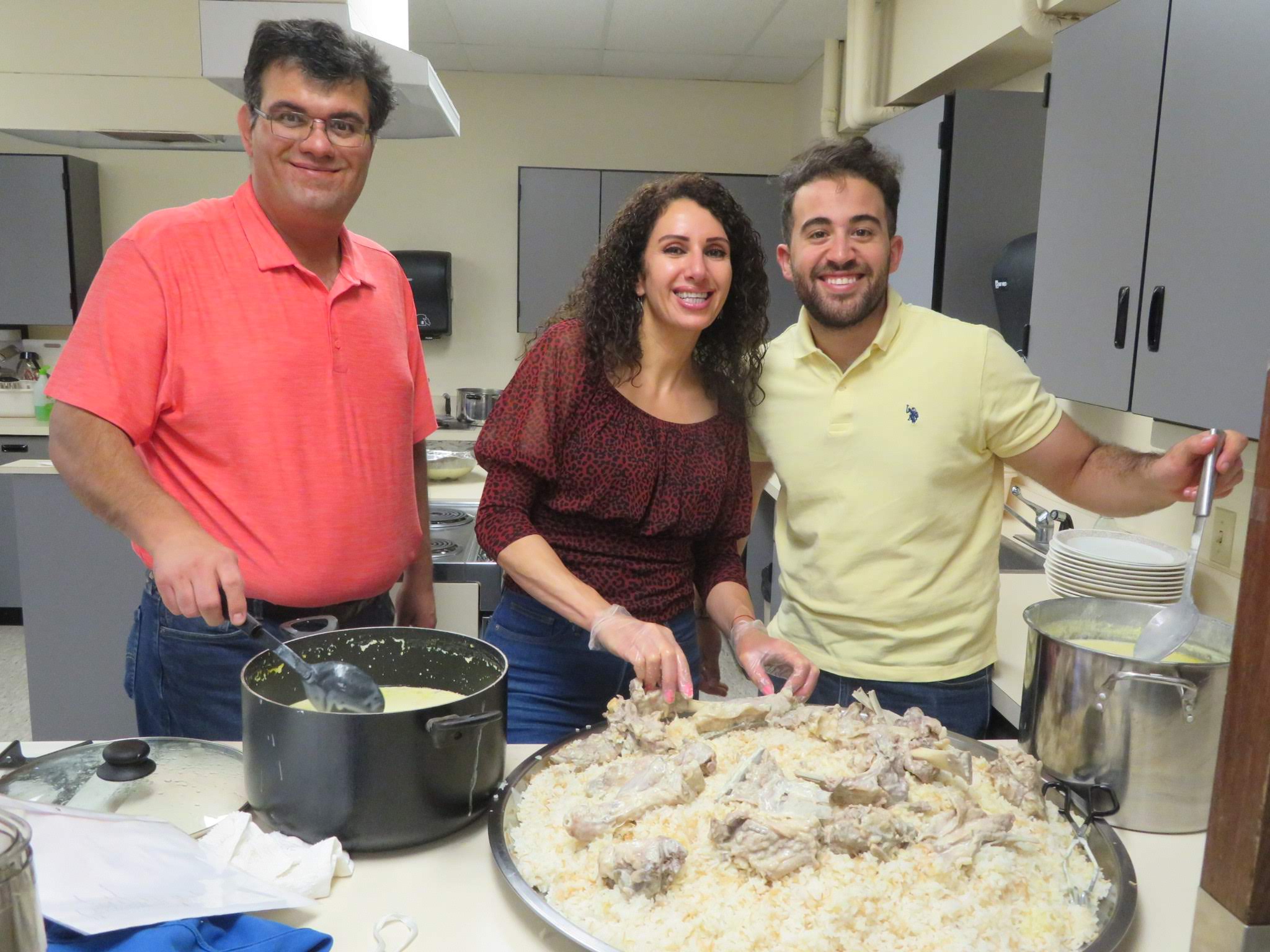 three adults cooking a traditional Jordanian dish