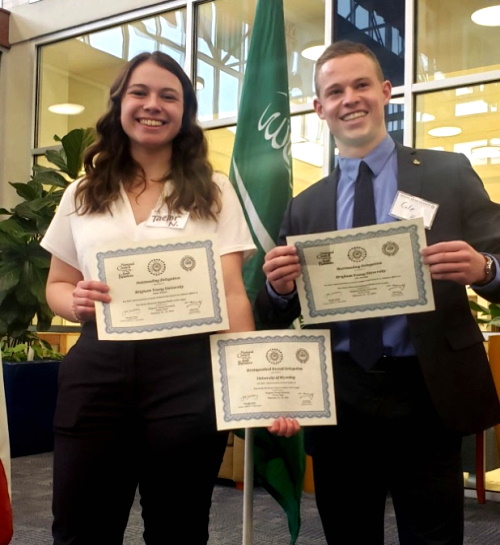 Two students holding certificates