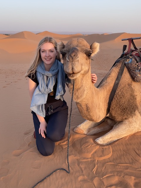 maeve knepper next to a camel in the sahara desert in morocco