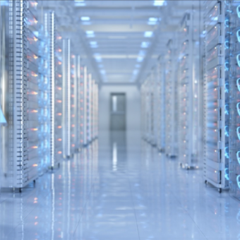 Futuristic looking data center with racks on both sides looking down the middle of a row