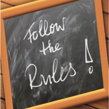 small chalkboard with handwritten "follow the rules"