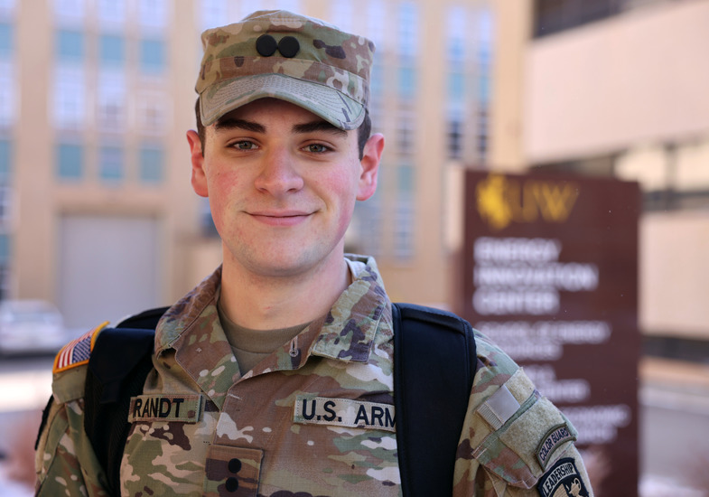 An Army ROTC cadet smiles while wearing their uniform.