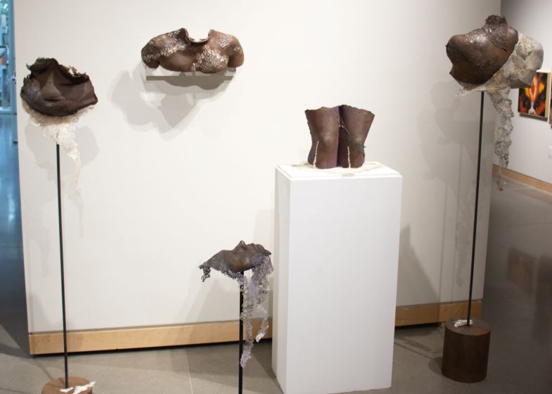 Art gallery display of 3-D bronze sculptures of disembodied body parts.