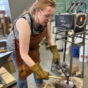 Blacksmithing student working with tools