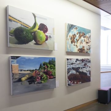 Student paintings on display in bright hallway