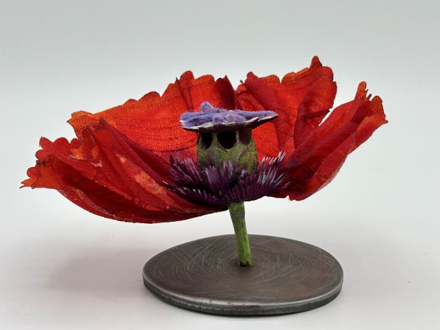 3-D Sculpture of a red flower losing pedals.