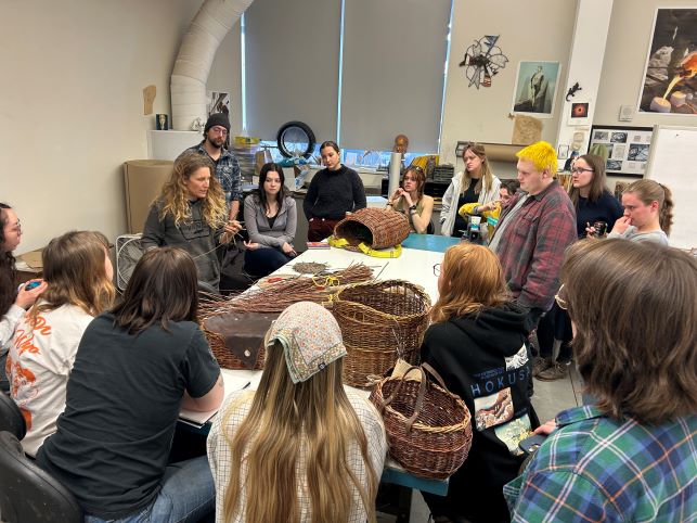 Group of students attending basket weaving demonstration