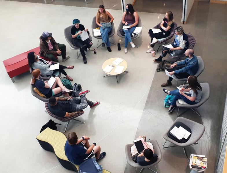 Areal perspective, looking down at students sitting in a circle.