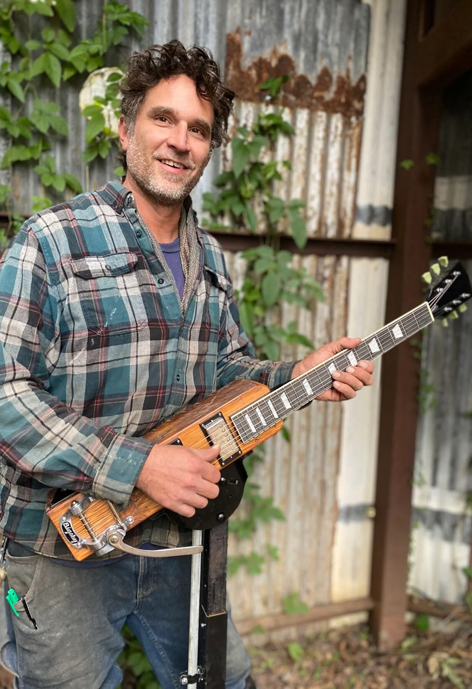 Person playing a unique stringed instrument.