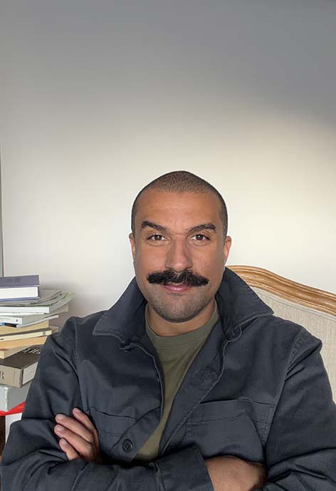 Smiling man wearing a light black jacket.