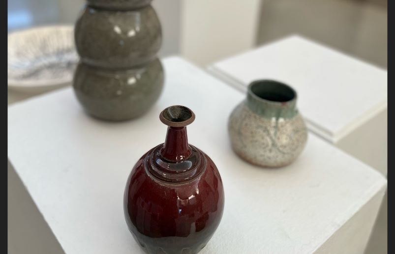 Red, white, and green ceramic vases on pedestal