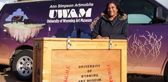 The curator stands in front of the Ann Simpson Artmobile.