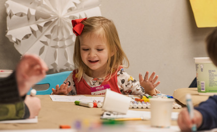 A preschool student excitedly examines art materials at a University of Wyoming Art Museum family event.