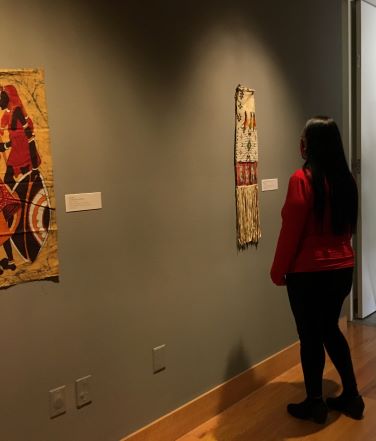 Debra Littlesun looking at artwork in gallery