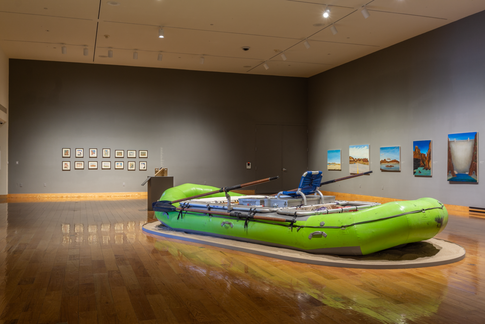 Gallery view of the "Patrick Kikut" exhibition, two gallery walls in the back and a large green raft in the foreground
