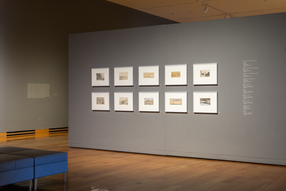 Gallery view of the "Thomas Moran" exhibition, framed prints arranged on a gray wall
