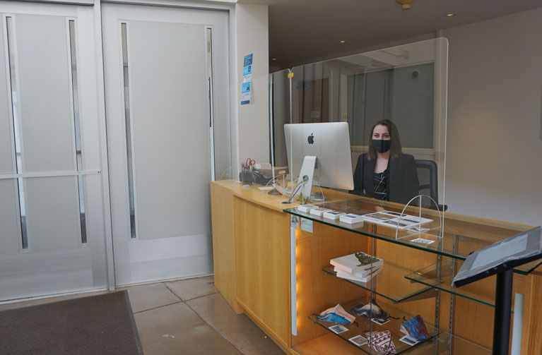 Visitor Services representative sitting at front desk