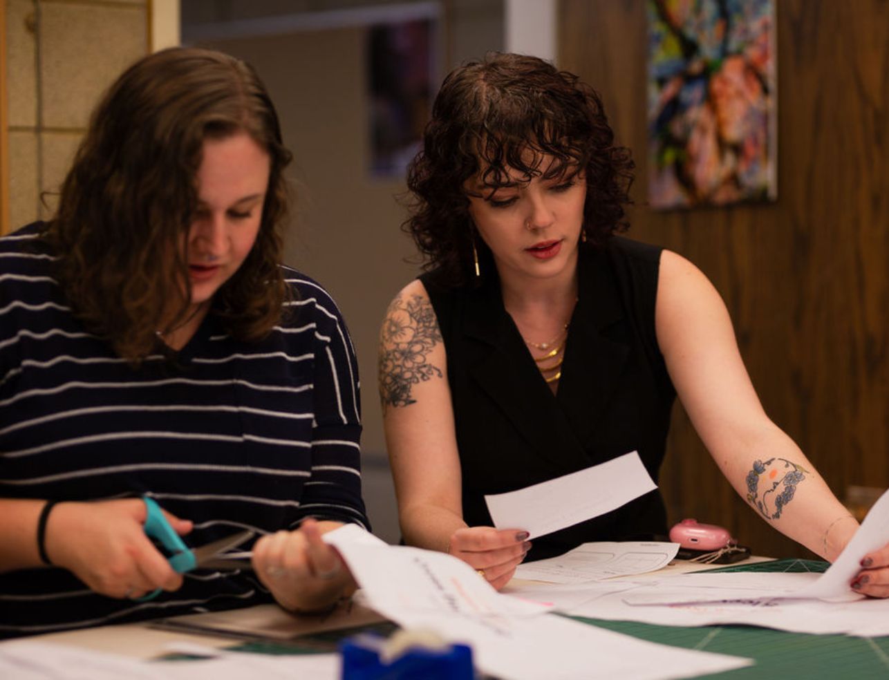 A UW professor works with a student while sitting at a desk