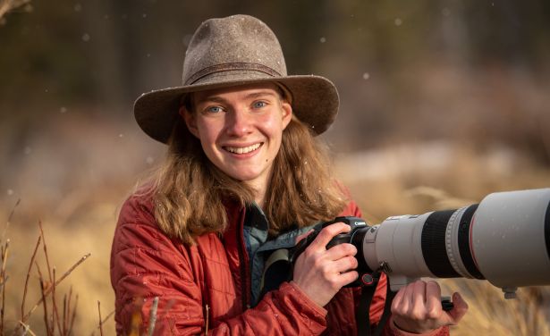 Julia Cook smiles and holds a camera