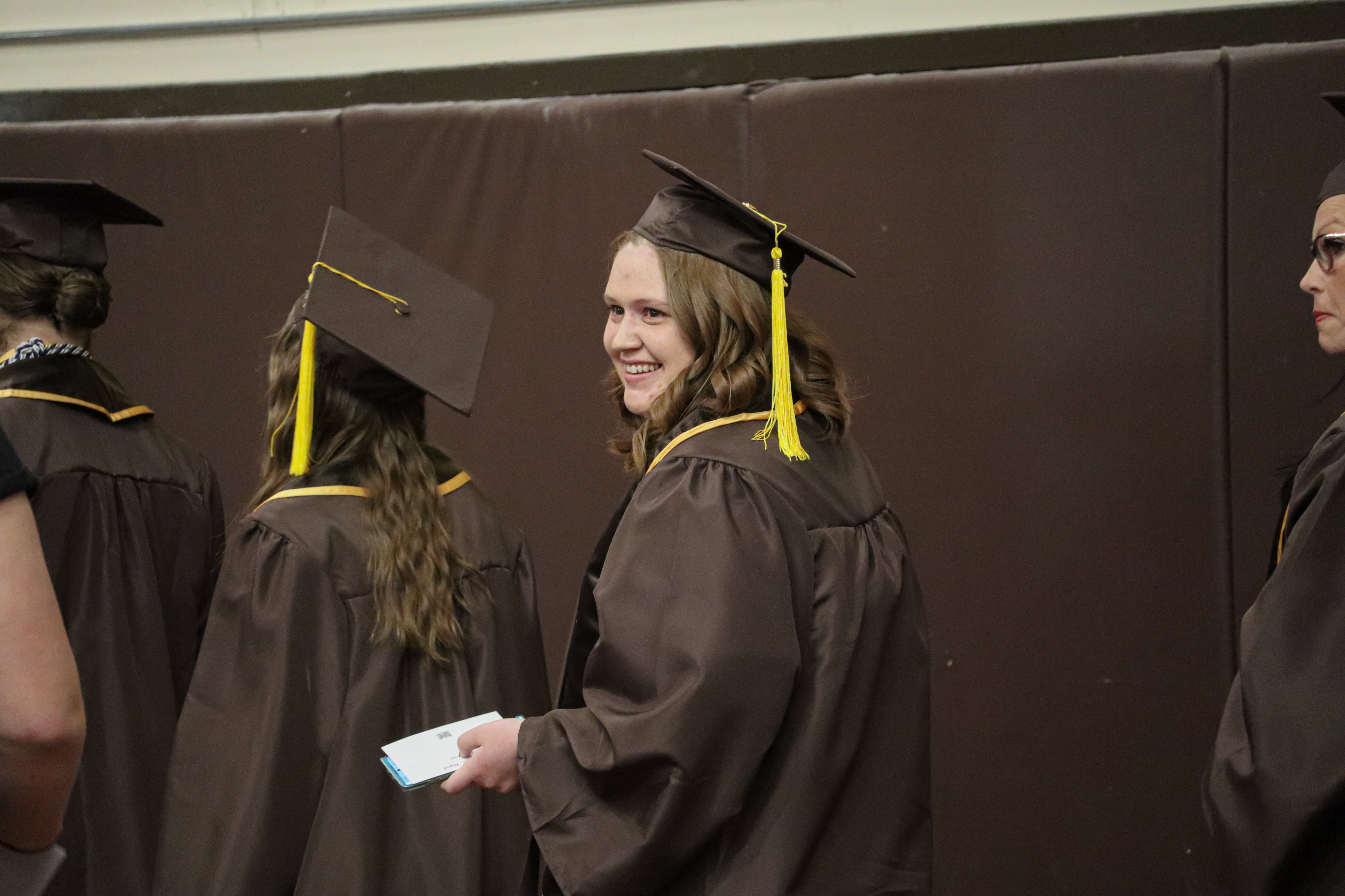 A 2025 graduate smiles over her shoulder before the ceremony.