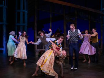 Students dance on stage during the production of bright star