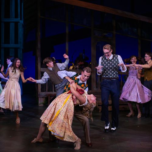 Cast members of bright star dance during the performance on stage