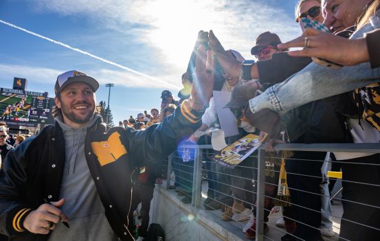 Josh Allen smiles and high fives fans.
