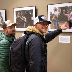 Guests look at Forrest Cole's photo exhibit.