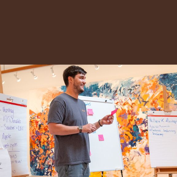A man presents at the front of the room.