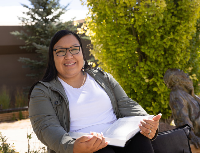 Student with notebook, smiling
