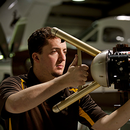 Person handling instrument with aircraft in background