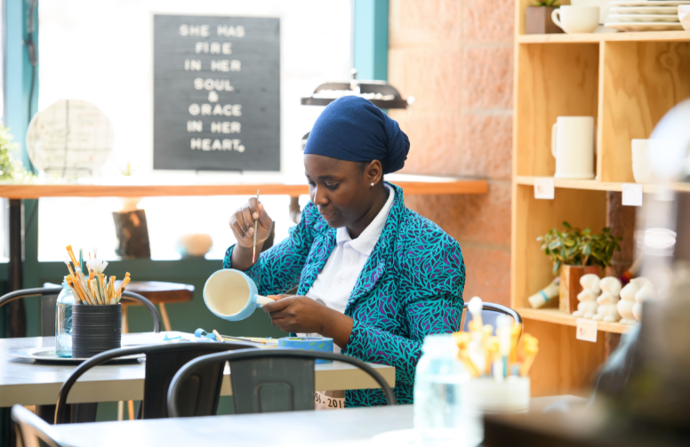Person painting a mug