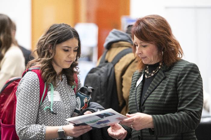 a student talking to a business rep at the College of Business career fair