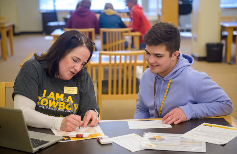 a student filling out paper work with a financial aid rep.