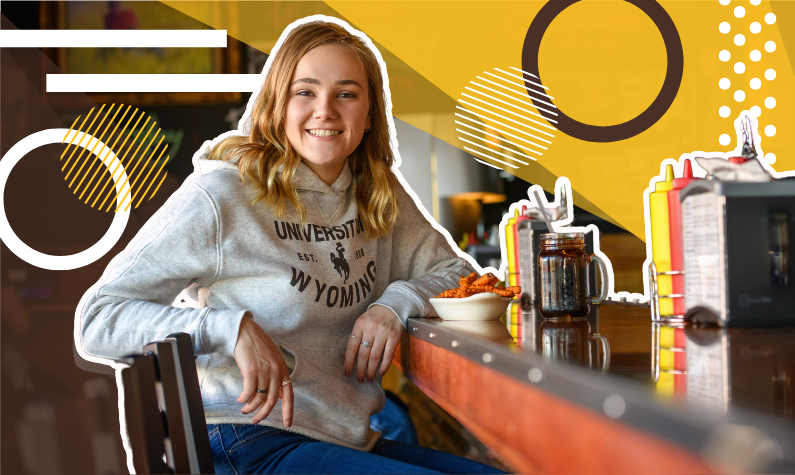 student in UW attire sitting at a counter for lunch