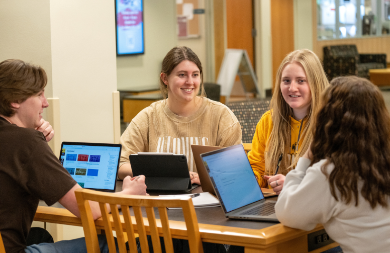 students in the library at a table together