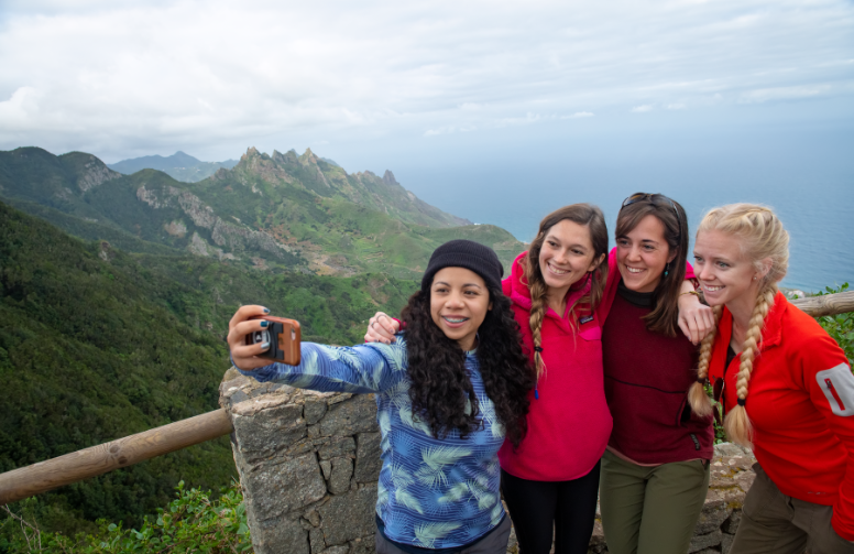 group of student pose for a photo on a study abroad trip on a rocky beach