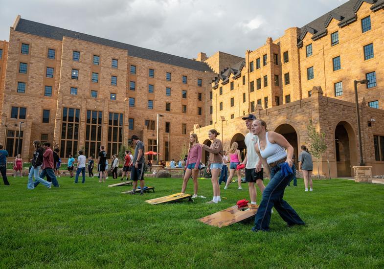 students play lawn games in front of the residence halls