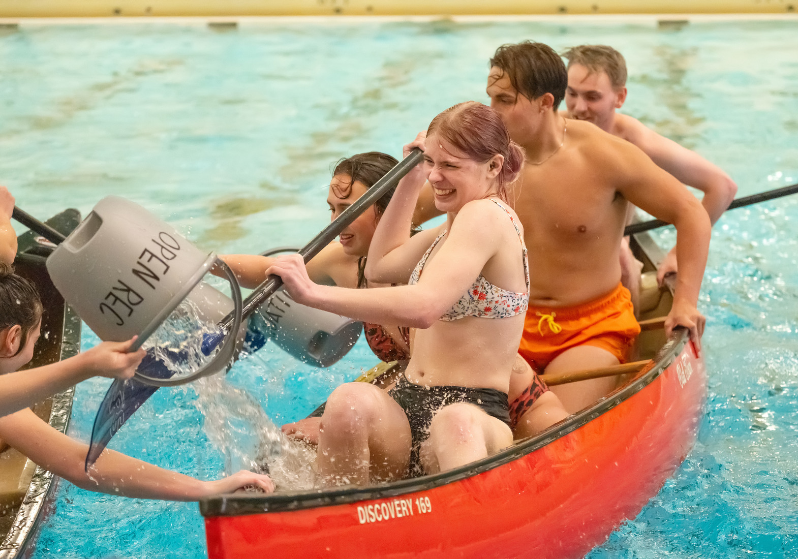 Students engage in a conoe battleship contest in a pool