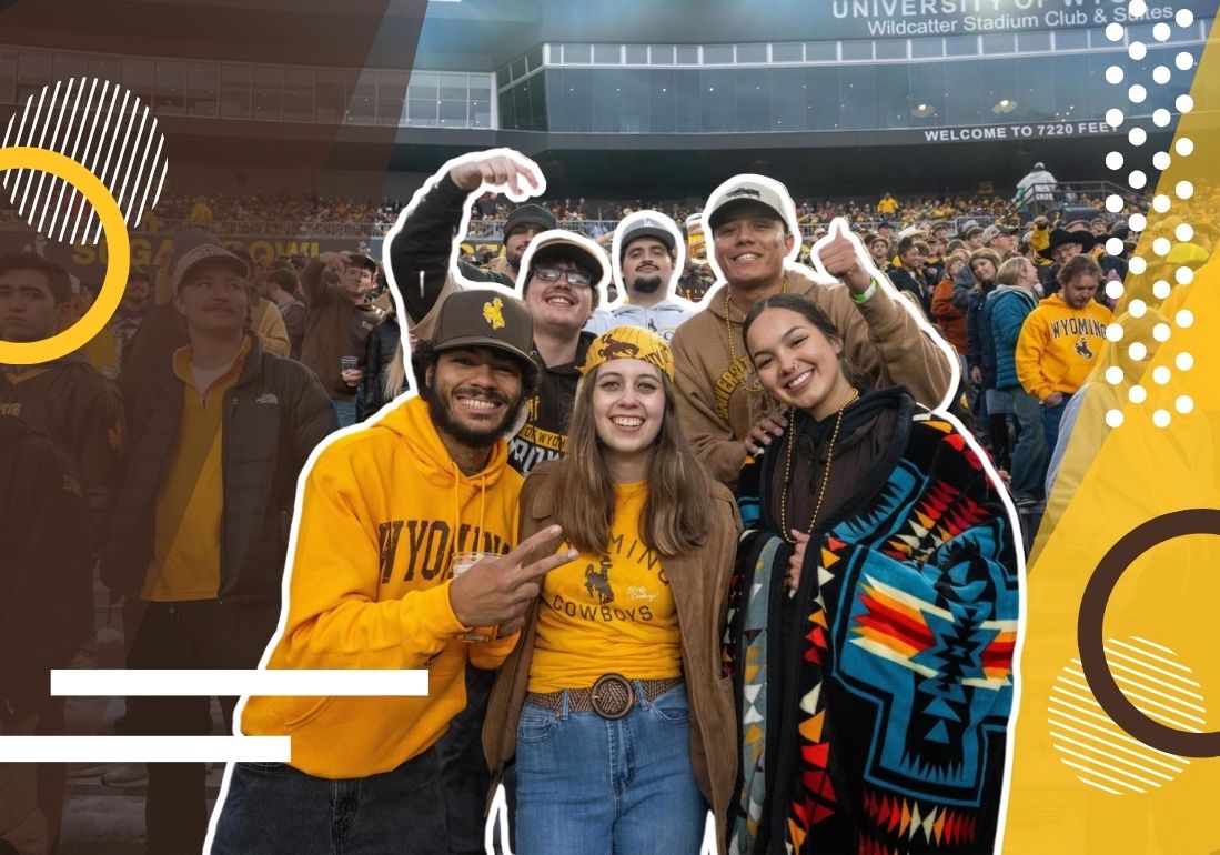 students at a football game together smile at the camera