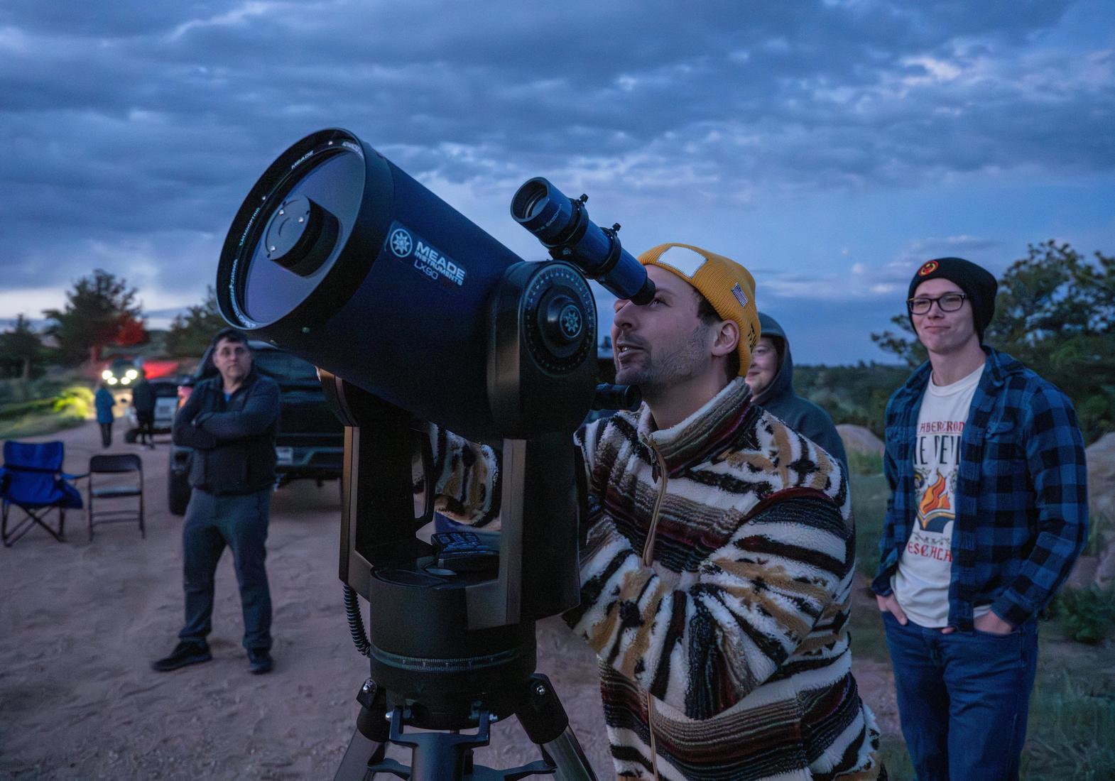 students look through a large telescope