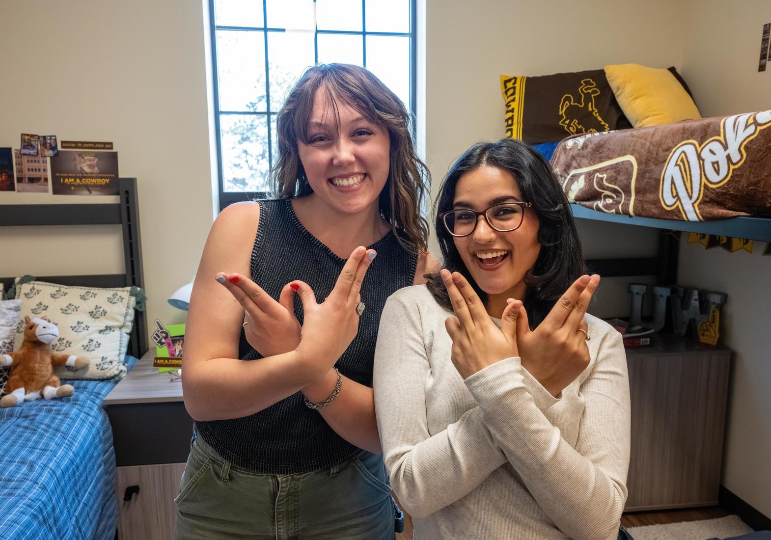 Two roommates hold up "W" hands for UW