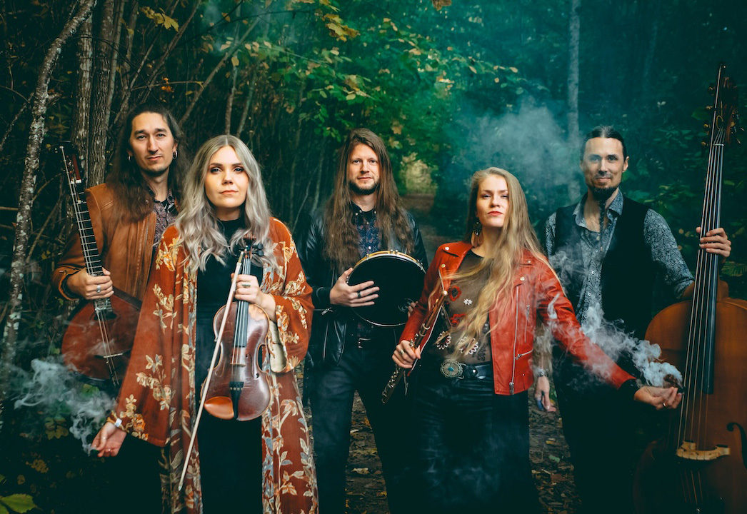 Band members holding instruments in a foggy forest