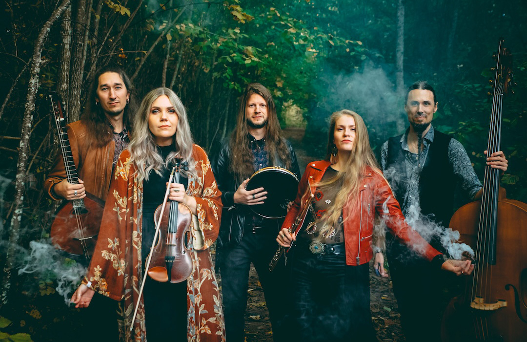 Group photo of band Frander, members holding various instruments in a foggy forest