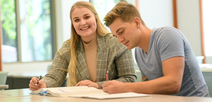Two students sharing a textbooks