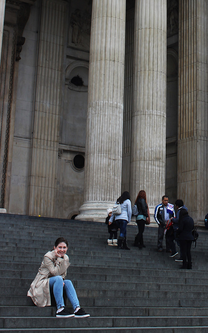 Emily sitting in front of columns in the UK
