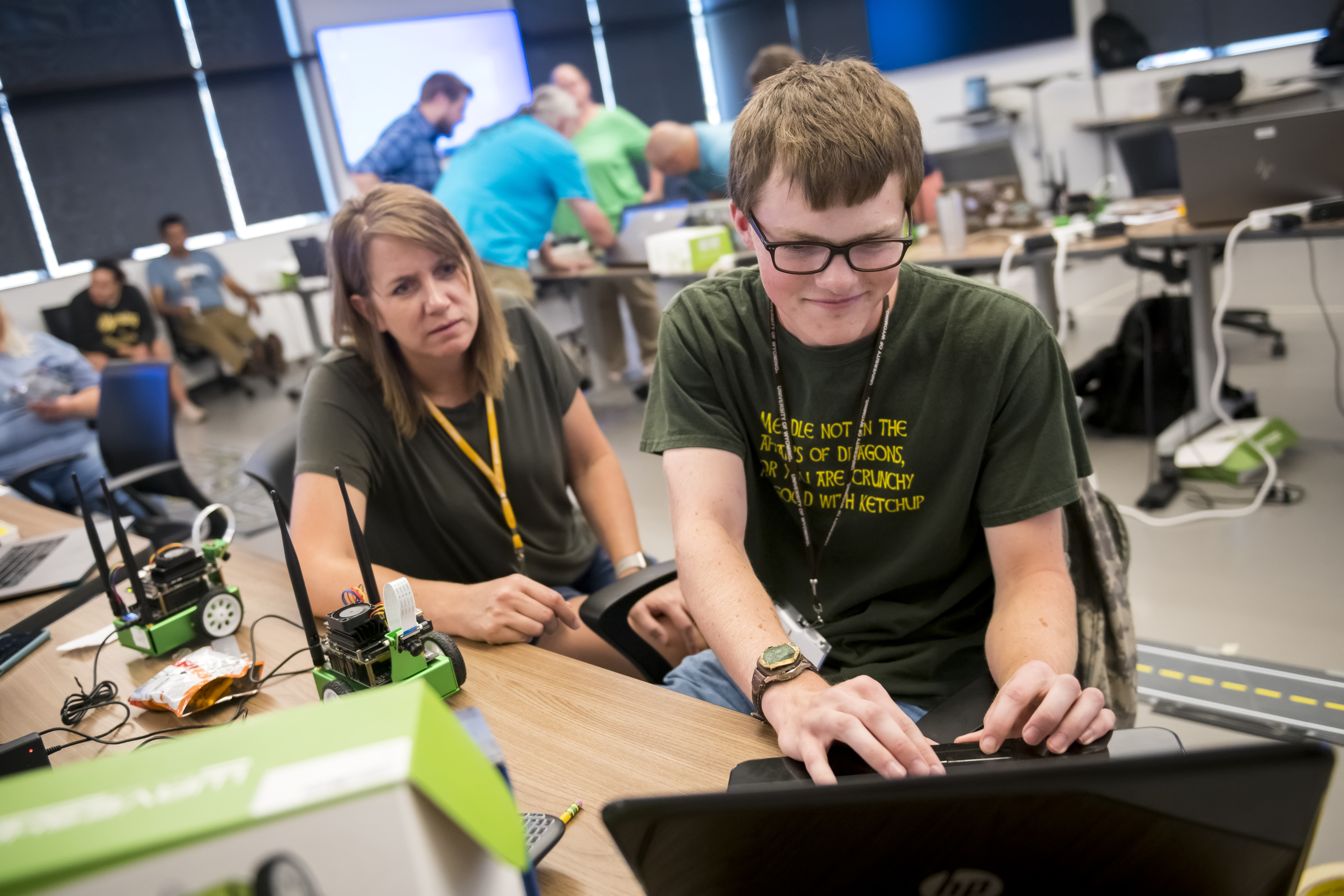 A teacher works to code with a high school student