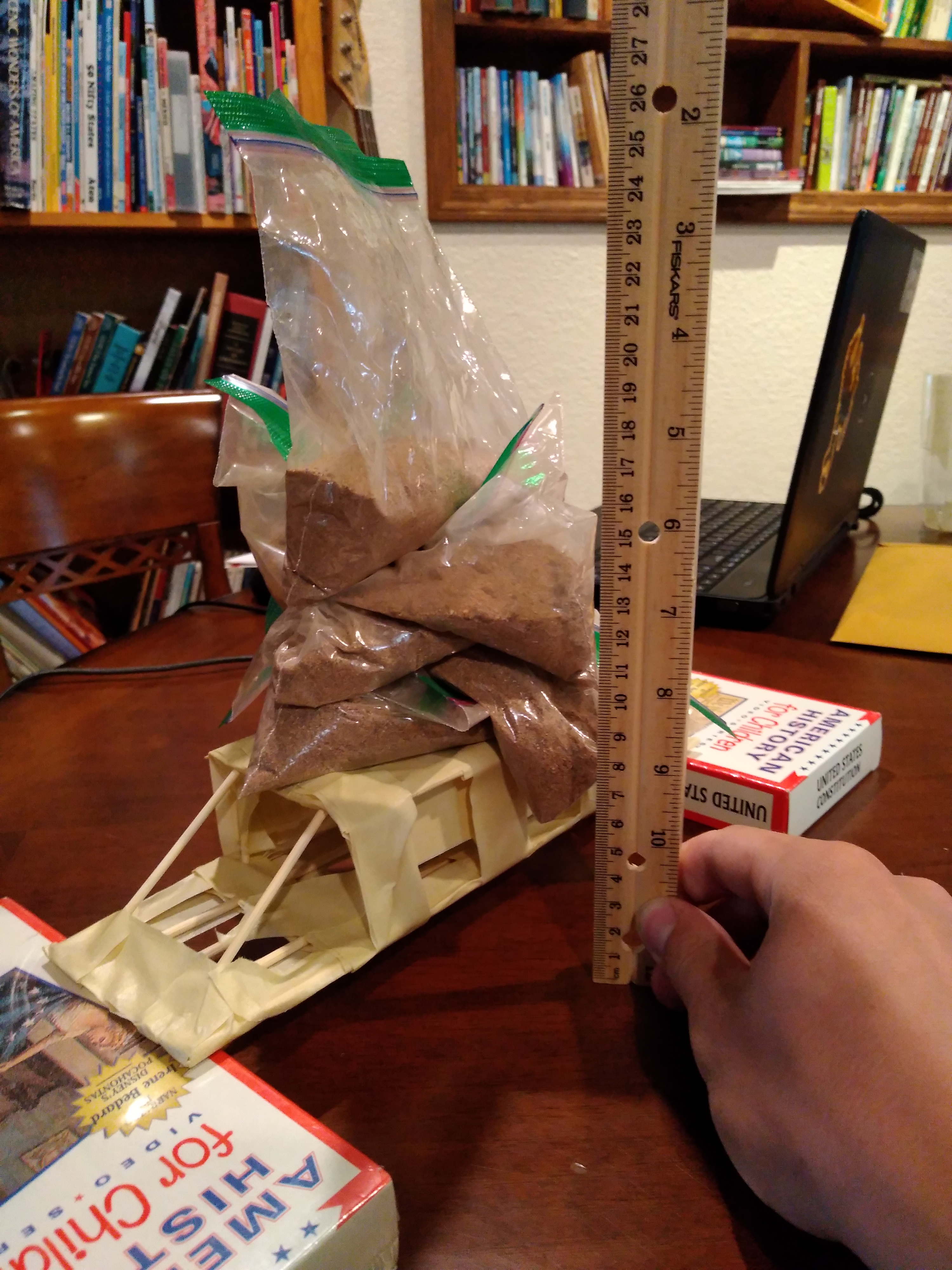Bridge made from straws with sandbag weights to test