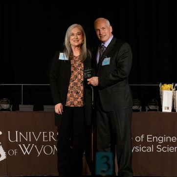 Jo Paintin receiving an Outstanding Staff Award from Cameron Wright at the banquet in 2025