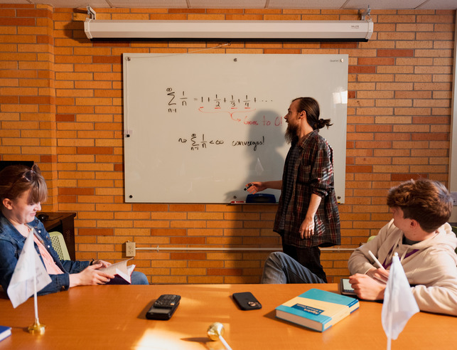 Teacher at whiteboard with two students